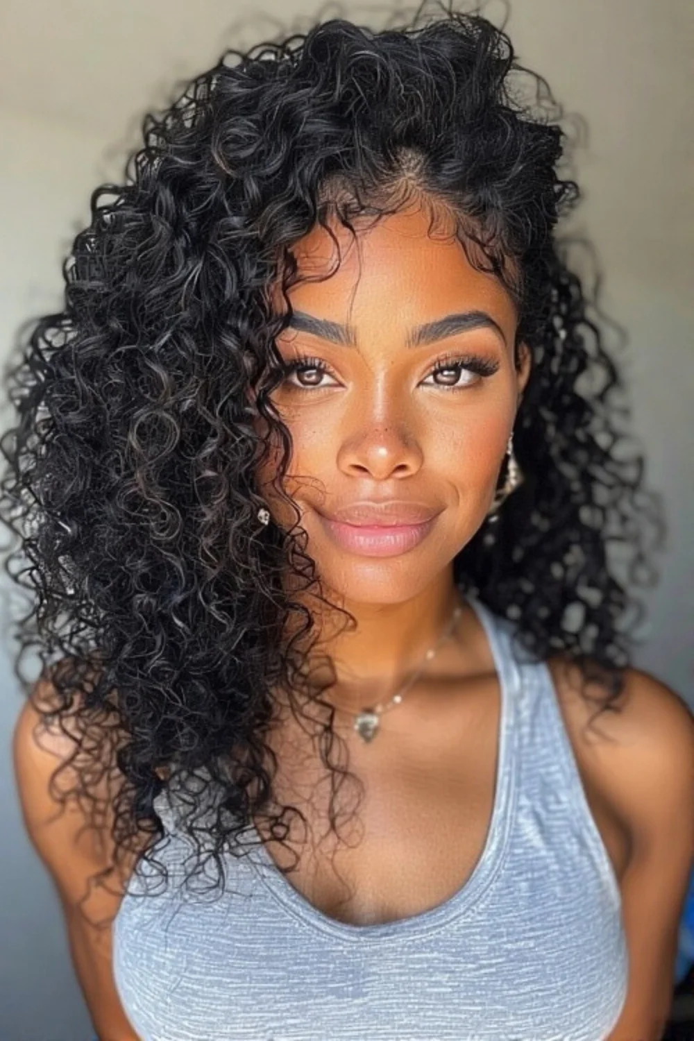 Side-swept natural curly bangs adding softness and frame.
