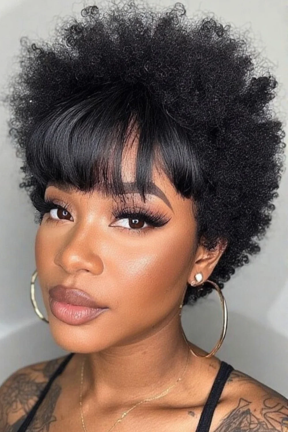 Bold afro bangs creating a statement with natural texture.
